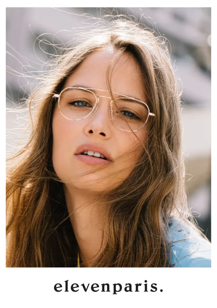 Junge Frau mit langen blonden Haaren und einer goldenen Metallbrille